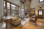 Great room with large fireplace, floor to ceiling windows, and ample seating